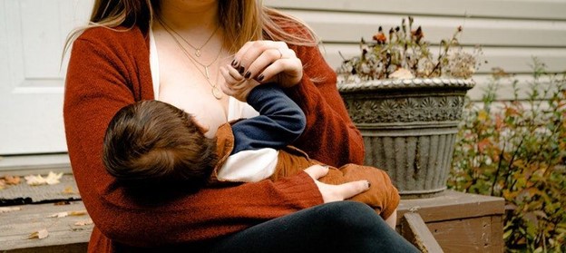 Mother breastfeeding after breast augmentation (model)