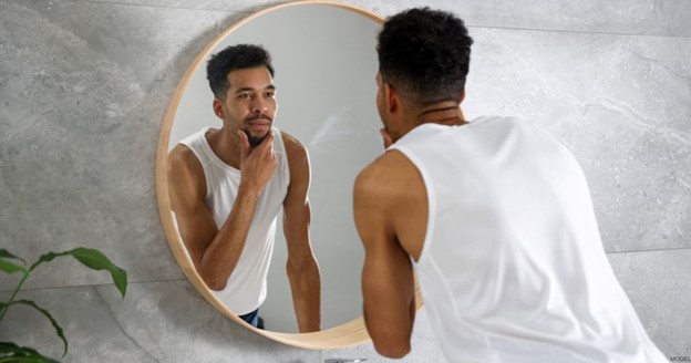 Man looking at his reflection in the mirror (model)