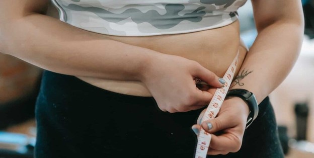 Woman measuring her waist (model)