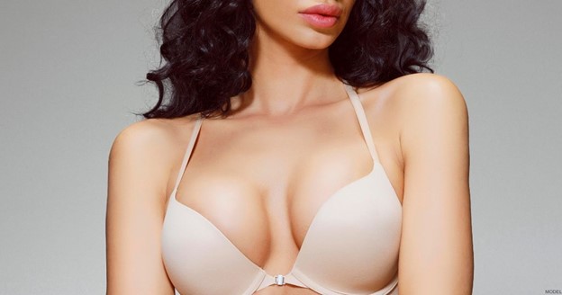 Woman showing off her breast implant results (model)